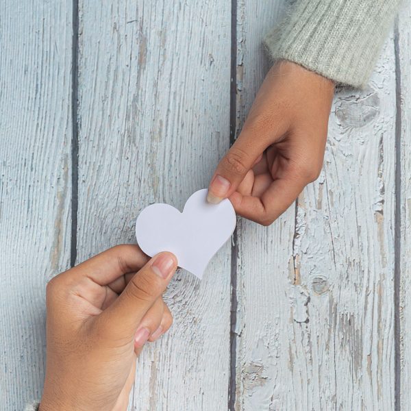mani che tengono un cuore di carta