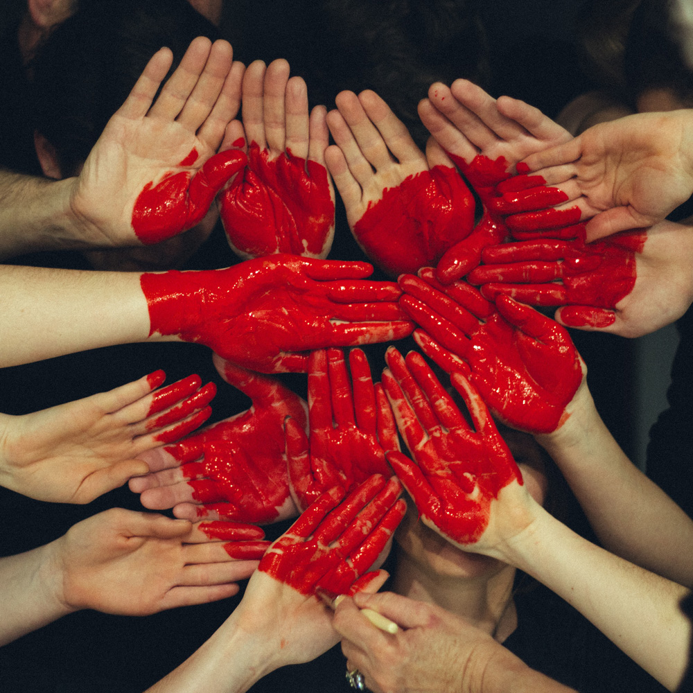 mani di persone e cuore rosso